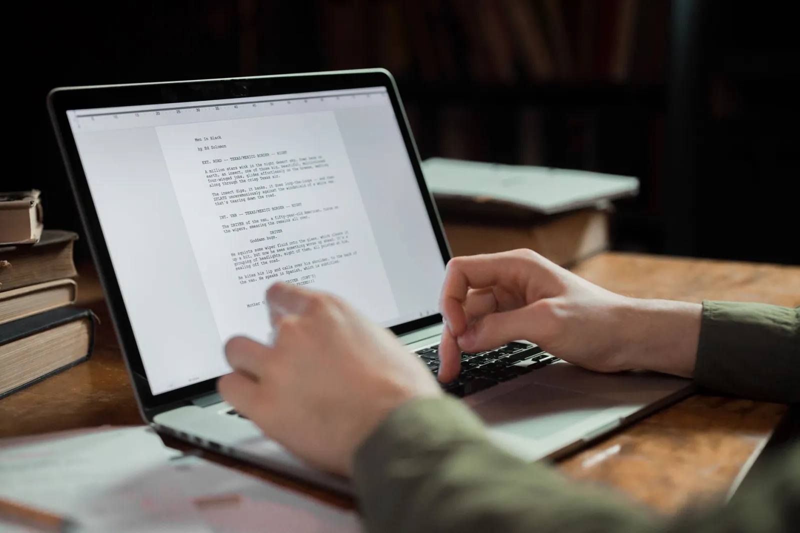 Mãos digitando em um notebook com um texto na tela